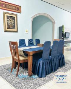 a dining room with a table and blue chairs at Homestay AZ Padang Serai in Padang Serai