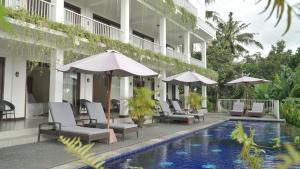 a hotel with a swimming pool with chairs and umbrellas at Aurelia Villa 1 in Lajor