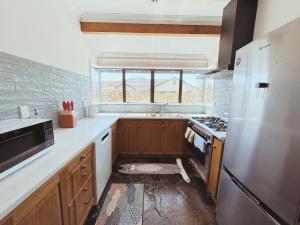 a kitchen with a sink and a stove top oven at Redwoods Lodge - 6BR & 6BA - Large Groups - Free Parking in Rotorua