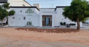 a white building with a tree in front of it at Modern and spacious luxury villa for rent 2 bedrooms in Nouakchott