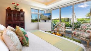a bedroom with a bed and a living room with windows at PUALANI VILLA Single Level 4BR KaMilo Home with Pool and Cottage in Waikoloa