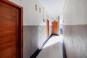 a hallway of a house with a door and white walls at Soka Asri Guest House near Bali Zoo RedPartner in Darmasaba
