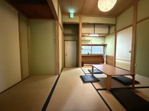 una habitación vacía con una mesa en el medio en 館山市犬石戸建 自然に囲まれた森のコテージ 6DK 最大18名宿泊可 パーティー BBQ 花火ok, en Tateyama
