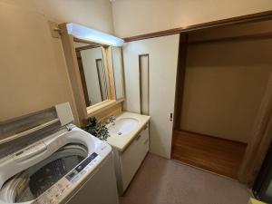 Un baño con lavadora y lavabo. en 館山市犬石戸建 自然に囲まれた森のコテージ 6DK 最大18名宿泊可 パーティー BBQ 花火ok, en Tateyama 47 fotos más