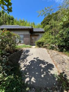 una casa con un camino de entrada que conduce a un garaje en 館山市犬石戸建 自然に囲まれた森のコテージ 6DK 最大18名宿泊可 パーティー BBQ 花火ok, en Tateyama