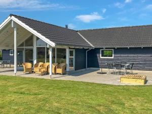 una casa con un patio con sillas y mesas en 12 person holiday home in Idestrup-By Traum, en Bøtø By
