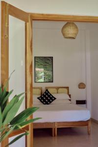 un dormitorio con una cama y un espejo en Mayava Villa, en Ahangama