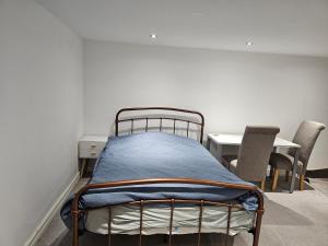 a bed in a room with chairs and a table at Oxford Studios in Altrincham