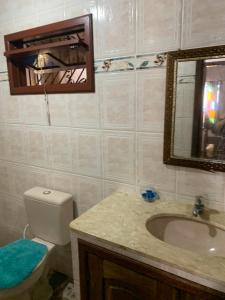 ein Badezimmer mit Toilette, Waschbecken und Spiegel in der Unterkunft Casa Sun and Sea in Salinópolis + 6 Fotos