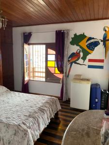 Schlafzimmer mit einem Bett, einem Fenster und einem Tisch in der Unterkunft Casa Sun and Sea in Salinópolis