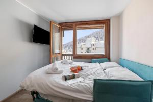une chambre avec un lit avec deux chaises et une fenêtre dans l'établissement Studio Valleverde 21D Ski In Ski Out - Happy Rentals, à Borgata Sestriere
