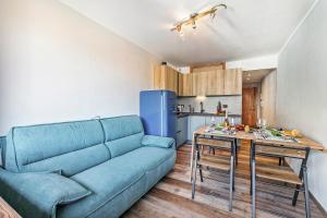 un salon avec un canapé bleu et une cuisine dans l'établissement Studio Valleverde 21D Ski In Ski Out - Happy Rentals, à Borgata Sestriere 12 autres photos