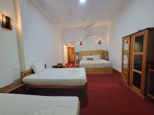 ein Hotelzimmer mit zwei Betten und einem Fenster in der Unterkunft River Resort by The Ceylon Adventure Sports Kithulgala in Kitulgala