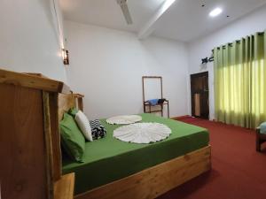 ein Schlafzimmer mit einem großen grünen Bett in einem Zimmer in der Unterkunft River Resort by The Ceylon Adventure Sports Kithulgala in Kitulgala
