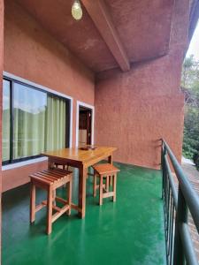 Ein Tisch und zwei Stühle auf einem Balkon mit grünem Bodenbelag in der Unterkunft River Resort by The Ceylon Adventure Sports Kithulgala in Kitulgala