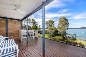 a large deck with a table and a view of the water at Zahirs Retreat in North Arm Cove