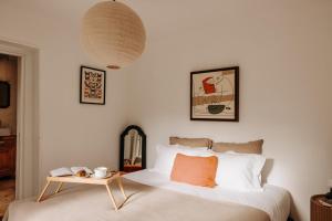 a bedroom with a bed with a table next to it at Domaine des Pousses, Chambres d'hôtes au coeur d'un village de campagne in Droue-sur-Drouette