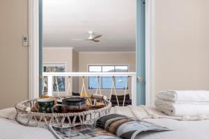 een bed met een dienblad met servies en handdoeken bij Zahirs Retreat in North Arms Cove