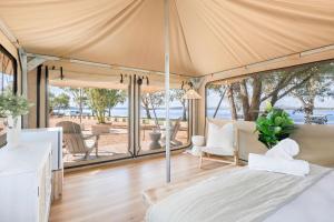 a tent with a bed and chairs in a room at Reflections Lake Keepit - Holiday Park in Keepit