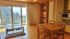 ein Esszimmer mit einem Tisch und einer Mikrowelle in der Unterkunft イザリCafe in Yokoo