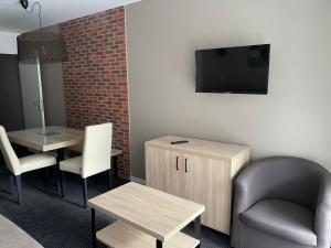 a waiting room with a chair a table and a tv at Studio à Gourette avec piscine, 4 pers., animaux admis - FR-1-860-42 in Gourette