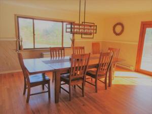 a dining room with a wooden table and chairs at Charming Cabin Retreat in the Foothills of the Adirondacks in Fort Ann, New York in Fort Ann