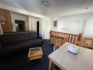 ein Wohnzimmer mit Sofa und Tisch in der Unterkunft Gourette : Studio Duplex 7 pers, Piscine & WIFI - FR-1-859-9 in Gourette