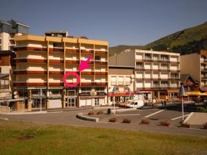 ein großes Apartmenthaus mit einem rosa Pfeil darauf in der Unterkunft Studio confort à Gourette pour 4 pers, animaux admis - FR-1-859-15 in Gourette