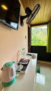 a kitchen counter with a stove with a tea kettle on it at Ella Deck Villa in Ella +75 photos