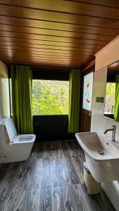 a bathroom with two sinks and a toilet and a window at Ella Deck Villa in Ella