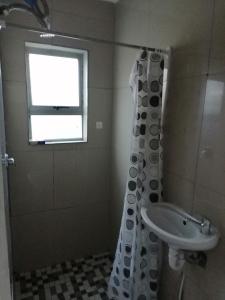 een badkamer met een douchegordijn en een wastafel bij 72 the trout lodge in Goodwood