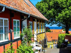a red and yellow house with white windows at 4 person holiday home in Svaneke in Svaneke