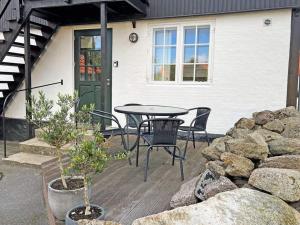 a patio with a table and chairs in front of a house at 4 person holiday home in Svaneke in Svaneke