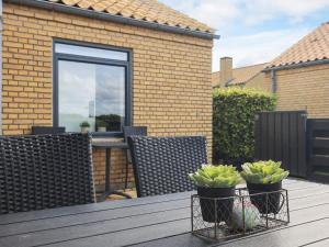 Una mesa con dos plantas en macetas en un patio. en Holiday home- Free Water Park Access, en Middelfart