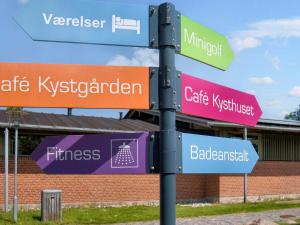 eine Stange mit Straßenschildern vor einem Gebäude in der Unterkunft 6 person holiday park home in Gilleleje in Gilleleje