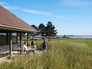 a group of people sitting at a table in a field at Holiday home on a holiday park in Karrebæksminde in Karrebæksminde +117 photos