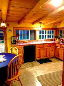 eine Küche mit Holzschränken und einem Tisch und Stühlen in der Unterkunft Gorgeous Private Cottage Rental in the Black Hills of South Dakota in Nemo