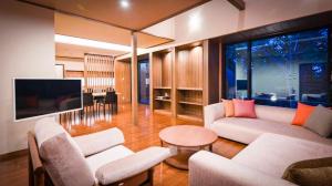 a living room with two couches and a tv at Kaze no Tani no Iori in Gamagori