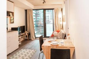 une cuisine et un salon avec une table et des chaises dans l'établissement Cosy modern 2BR home in the heart of Melbourne CBD, à Melbourne