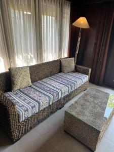 een rieten bank in een woonkamer met een tafel bij Villa Sage Bali in Darmasaba