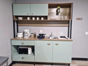 a small kitchen with a sink and a microwave at Casabela in Comayagua