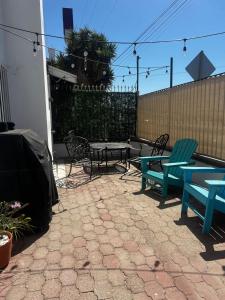 a patio with chairs and tables and a fence at Beautiful Home at Ensenada 3BR at DT BBQ GRILL in Ensenada