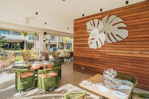 Ocean - Pool - BBQ - Resort - 3 Ensuite - Grand Baie في غراند بايَ: مطعم بطاولات وكراسي وجدار خشبي