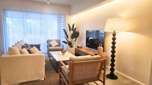 Ocean - Pool - BBQ - Resort - 3 Ensuite - Grand Baie في غراند بايَ: غرفة معيشة بها أريكة وطاولة وتلفزيون