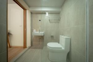 a bathroom with a toilet and a sink at The Nook Hotel in Chiang Mai