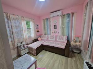 a pink bedroom with a bed and a table at Blessing Homestay Mae-On แม่ออน Chiang Mai in Ban On Luai