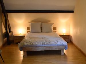 a bedroom with a bed with two lamps on the sides at Gîte calme et paisible en forêt, idéal pour famille et amis - FR-1-410-486 in Le Grand-Lucé