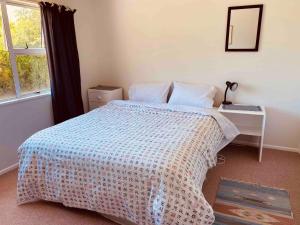 une chambre avec un lit, un bureau et une fenêtre dans l'établissement Lake Hawea Family Holiday Home, à Lake Hawea 1 autre photo