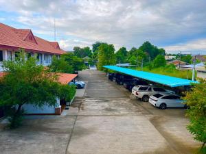 a parking lot with cars parked in front of a building at The Terrace Homestay Resort in Tak