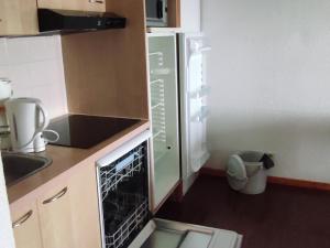 a small kitchen with a refrigerator and a trash can at Appartement Super Besse - 6 pers, Piscine, Parking, Balcon - FR-1-814-168 in Vassivière